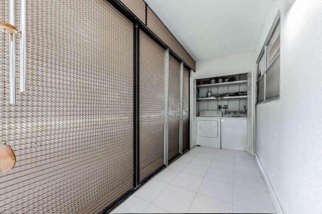 hall featuring separate washer and dryer and light tile patterned floors