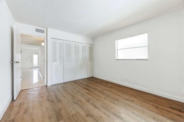 unfurnished bedroom with a closet and light hardwood / wood-style flooring