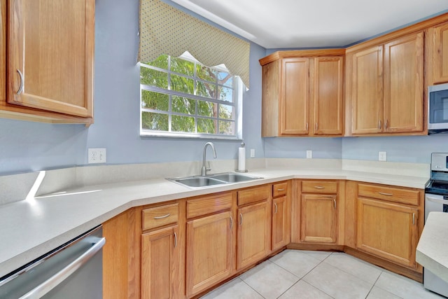 kitchen with light countertops, a sink, light tile patterned floors, and appliances with stainless steel finishes