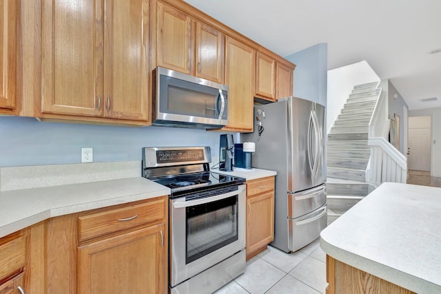 kitchen featuring light tile patterned flooring, light countertops, visible vents, and stainless steel appliances