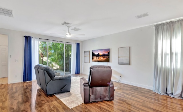 living area featuring visible vents, a ceiling fan, and wood finished floors