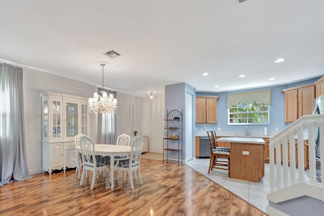 dining area with light wood finished floors, recessed lighting, a chandelier, and visible vents