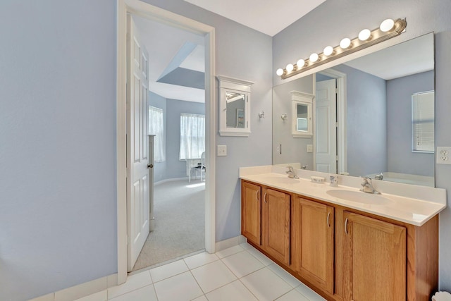 full bath with baseboards, double vanity, a sink, and tile patterned flooring