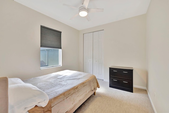 bedroom featuring a closet, baseboards, a ceiling fan, and light colored carpet