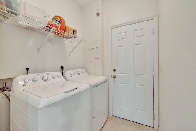 washroom with washing machine and dryer and light tile patterned floors