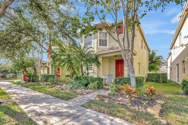 view of front of property with a front yard and stucco siding