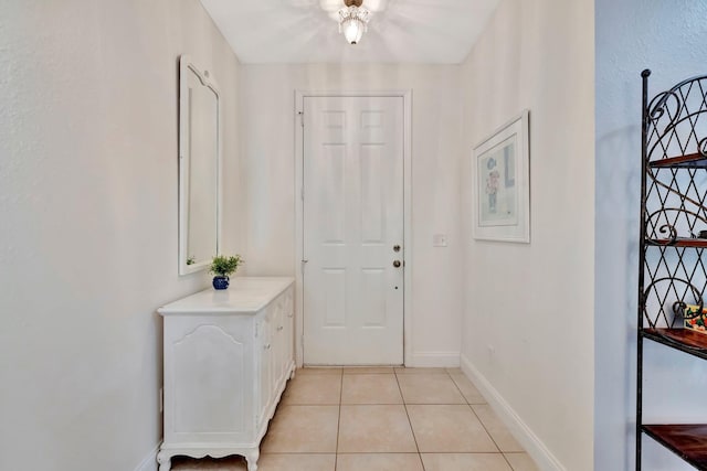 foyer featuring baseboards and light tile patterned floors