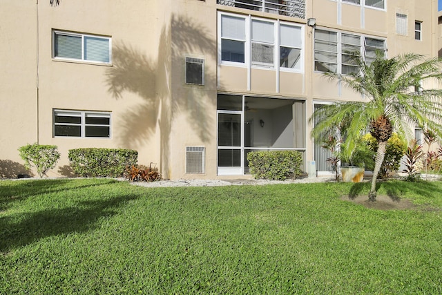 rear view of property featuring a lawn