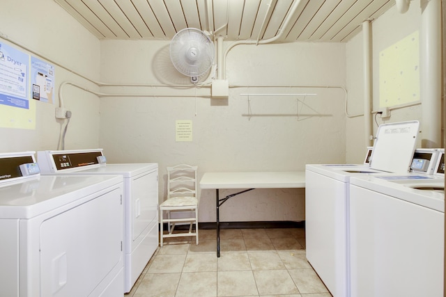 laundry area with light tile patterned floors and washing machine and clothes dryer