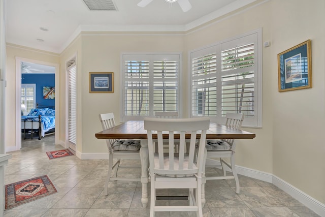 tiled dining room with ceiling fan and crown molding