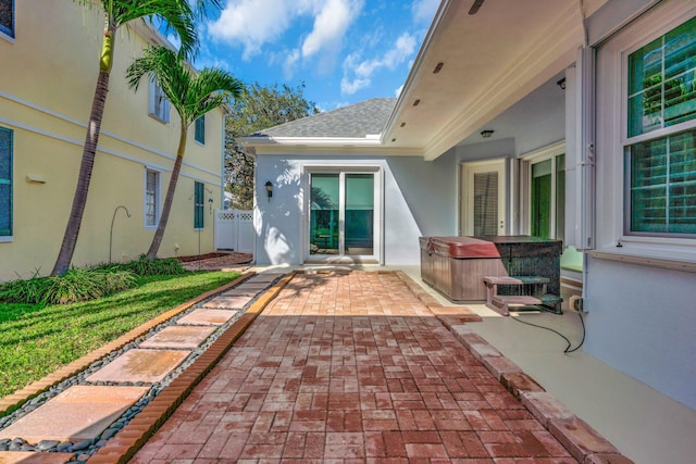 entrance to property with a hot tub and a patio area