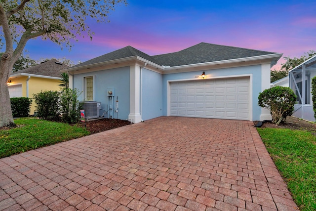 ranch-style house with central AC and a garage