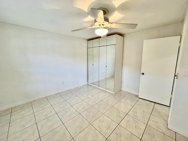 unfurnished bedroom featuring a textured ceiling, a closet, and ceiling fan