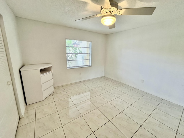 spare room with ceiling fan and a textured ceiling