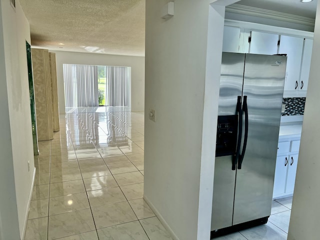 hallway featuring light tile patterned floors and a textured ceiling