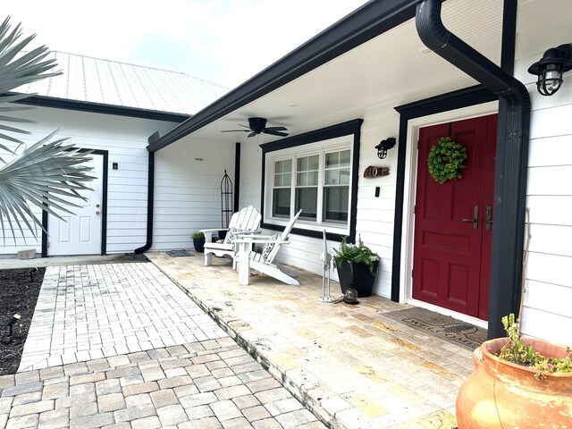 entrance to property featuring a porch and ceiling fan