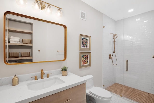 bathroom with vanity, toilet, and a shower with shower door