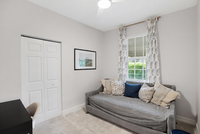 living area with ceiling fan and light colored carpet