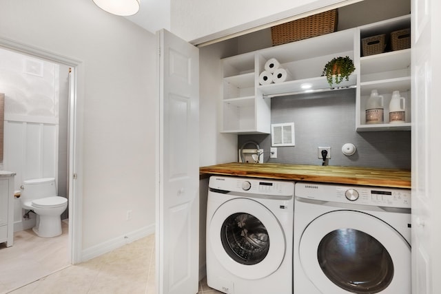 clothes washing area with light tile patterned floors and washing machine and dryer