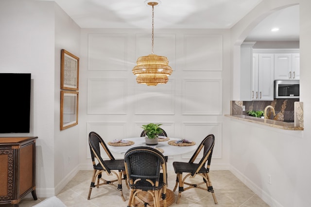 tiled dining space featuring a chandelier