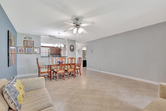 tiled dining area with ceiling fan with notable chandelier and a textured ceiling