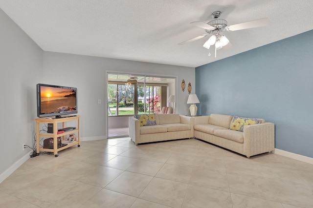 living room featuring ceiling fan and a textured ceiling