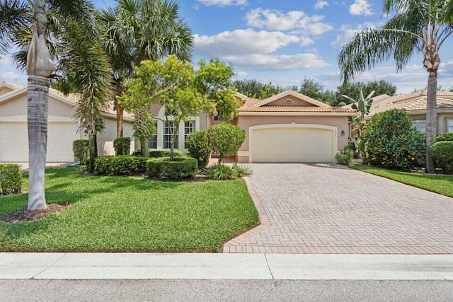 mediterranean / spanish house with a garage and a front lawn