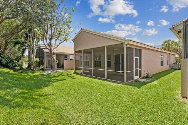 back of property with a sunroom and a yard