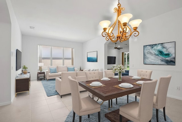 dining space featuring light tile patterned floors and ceiling fan with notable chandelier