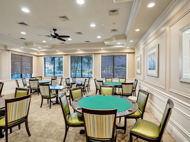 recreation room with ceiling fan, a raised ceiling, ornamental molding, and light carpet