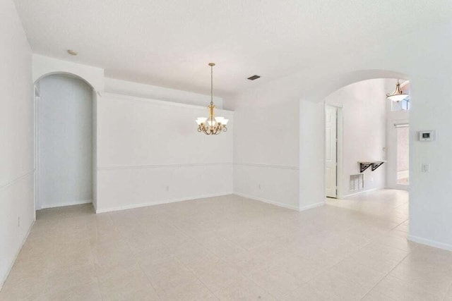 spare room featuring a notable chandelier