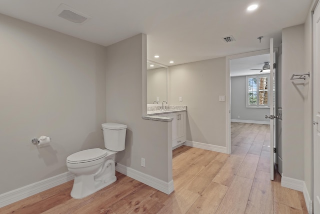 bathroom featuring toilet, baseboards, visible vents, and wood finished floors