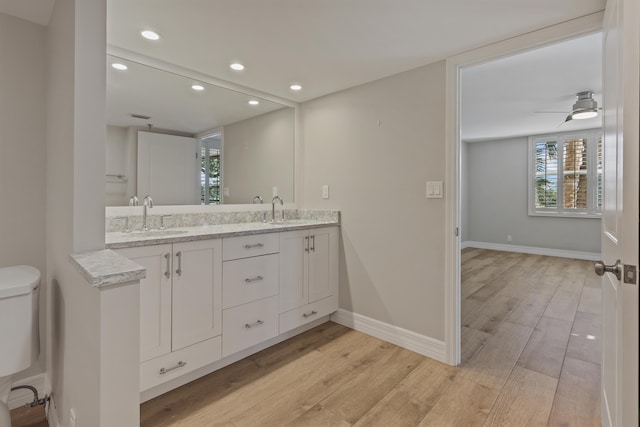 bathroom with toilet, a sink, and wood finished floors