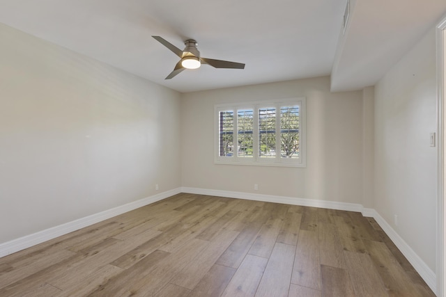 spare room featuring a ceiling fan, baseboards, and wood finished floors