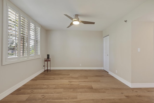 empty room featuring light wood-style flooring, baseboards, and ceiling fan