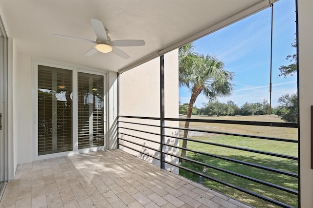 unfurnished sunroom with a ceiling fan