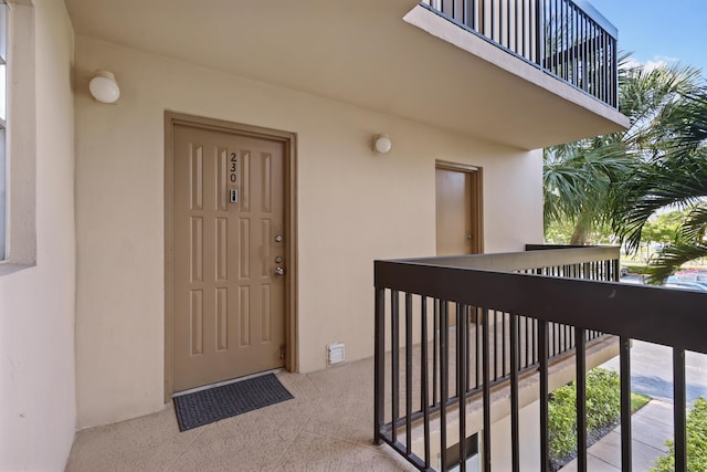 entrance to property with a balcony and stucco siding