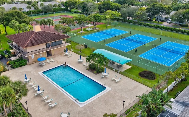 view of pool featuring a tennis court, a patio, and fence