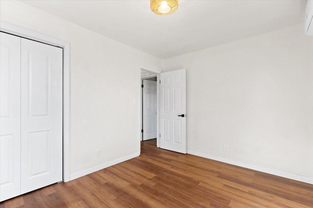 unfurnished bedroom featuring a closet and dark hardwood / wood-style floors