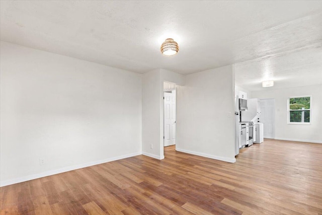 unfurnished room featuring light hardwood / wood-style floors and a textured ceiling