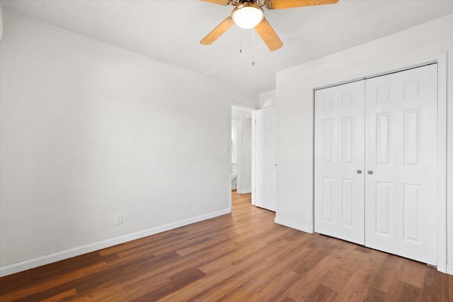 unfurnished bedroom with ceiling fan, a closet, and dark wood-type flooring