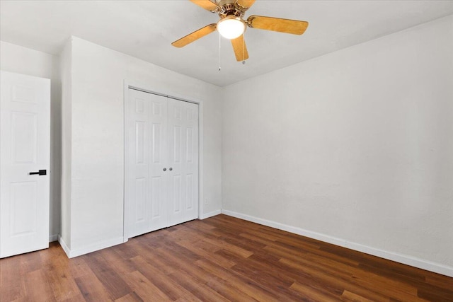 unfurnished bedroom featuring ceiling fan, dark wood-type flooring, and a closet