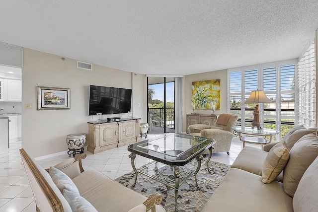 tiled living room featuring a textured ceiling and floor to ceiling windows