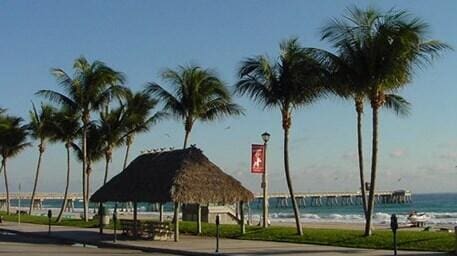 view of property's community with a view of the beach, a gazebo, and a water view