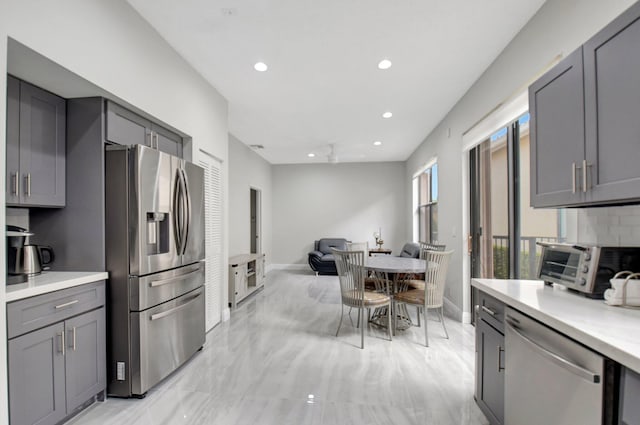 kitchen featuring stainless steel appliances, tasteful backsplash, and gray cabinetry