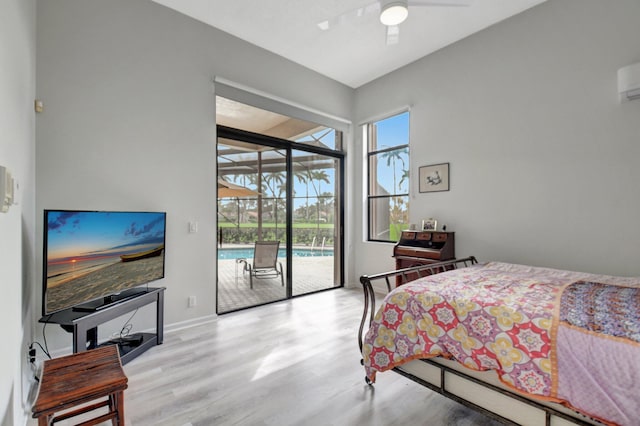 bedroom with an AC wall unit, access to exterior, ceiling fan, and light hardwood / wood-style flooring