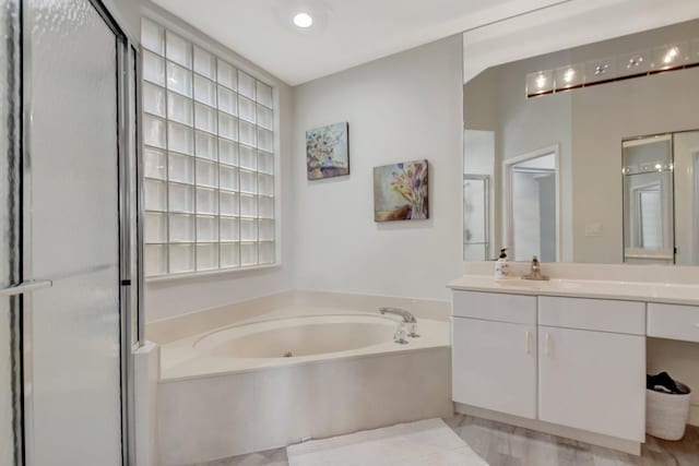 bathroom with vanity and shower with separate bathtub