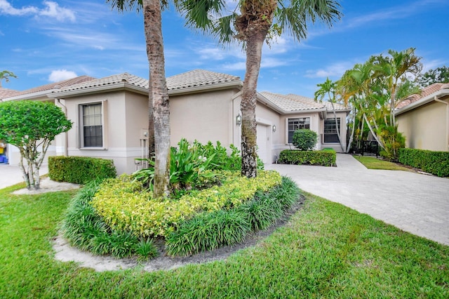 mediterranean / spanish house featuring a front lawn and a garage