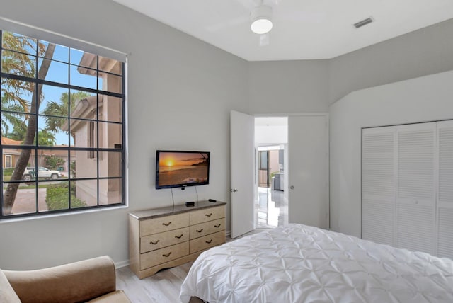 bedroom featuring ceiling fan, a closet, and light hardwood / wood-style flooring