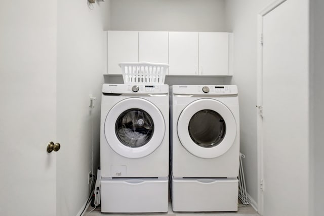 washroom featuring separate washer and dryer and cabinets